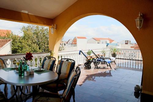 eine Terrasse mit Tisch und Stühlen auf einem Balkon in der Unterkunft Apartments Visnja in Vodice