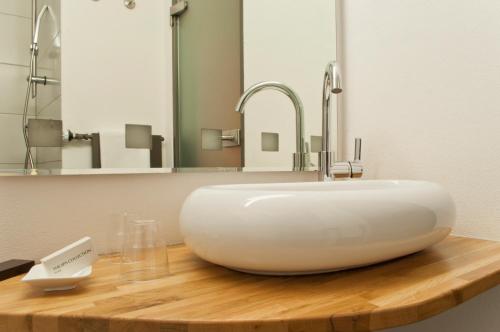 a white sink on a wooden counter in a bathroom at Hotel Credé in Kassel