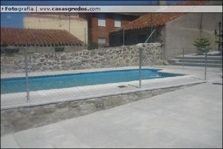 a swimming pool in front of a building at Casa Rural La Huerta Condesa in Escalonilla