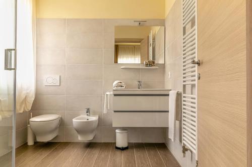 bagno con servizi igienici, lavandino e specchio di Villa Luisa Rooms&Breakfast a Peschiera del Garda