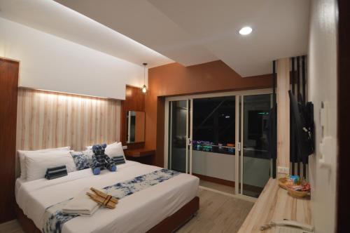 a bedroom with a large bed with towels on it at UD Capital Hotel in Udon Thani