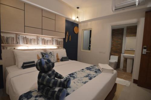 a teddy bear sitting on a bed in a bedroom at UD Capital Hotel in Udon Thani