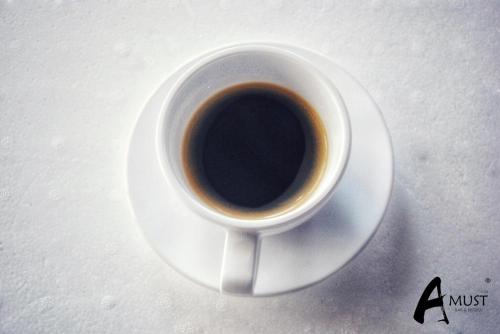 a cup of coffee sitting on a white plate at UD Capital Hotel in Udon Thani