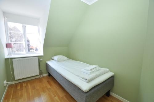 a small bedroom with a bed and a window at Boende Visby in Visby