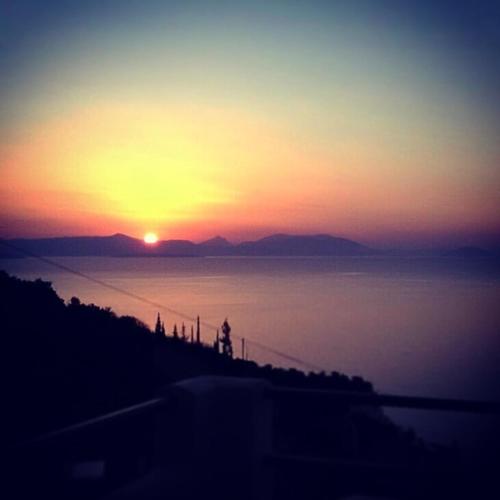 a sunset over a body of water with the sun at Blue Horizon Suites in Paralion astros