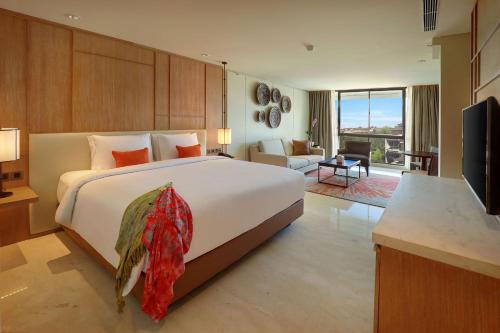 a bedroom with a large bed and a living room at Aryaduta Bali in Kuta