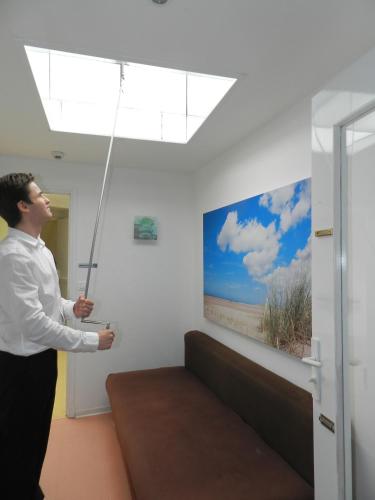a man is standing in a room holding a wand at Hôtel Le Vivier WISSANT - Centre Village - Côte d'Opale - Baie de Wissant - 2CAPS in Wissant