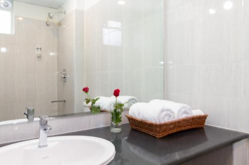 a bathroom with a sink and a mirror at Sanctum Suites Whitefield Bangalore in Bengaluru