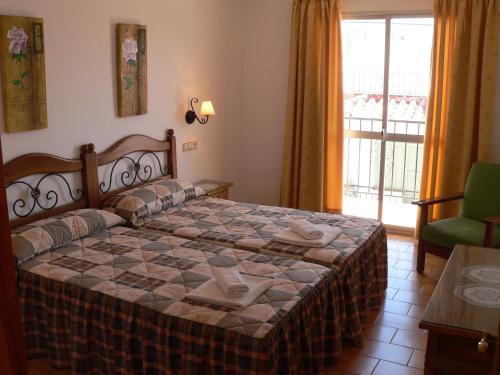 a bedroom with a bed with a table and a window at Apartamentos Casanova in Nerja
