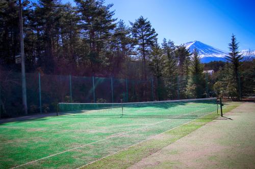a tennis court with a mountain in the background at Hotel Regina Kawaguchiko in Fujikawaguchiko