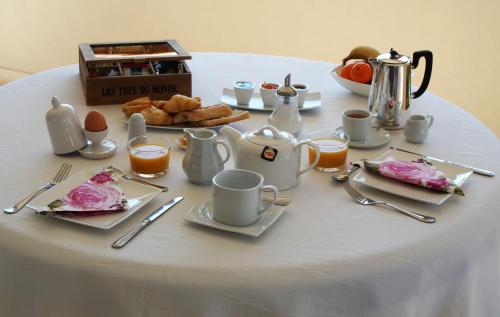 einen Tisch mit Teller mit Speisen und Kaffee darauf in der Unterkunft Les Lumières de Genève in Grilly