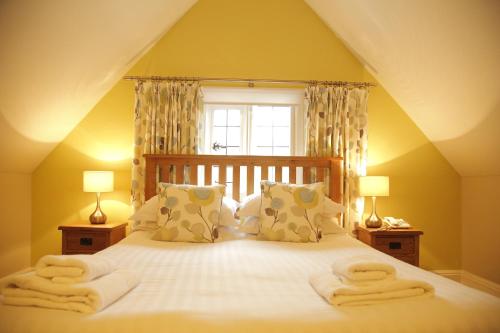 a bed with white sheets and pillows on top of it at B+B York in York