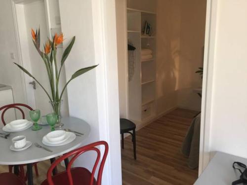 a table and chairs with a vase of flowers on it at Pasithea Holiday Apartments in Larnaka