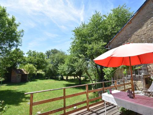 a table with an umbrella on a wooden deck at Bright holiday home in Gascony with garden in Gâcogne