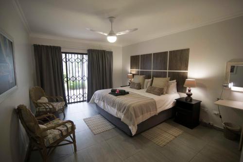 a bedroom with a large bed and a window at unit 55 la pirogue in Ballito