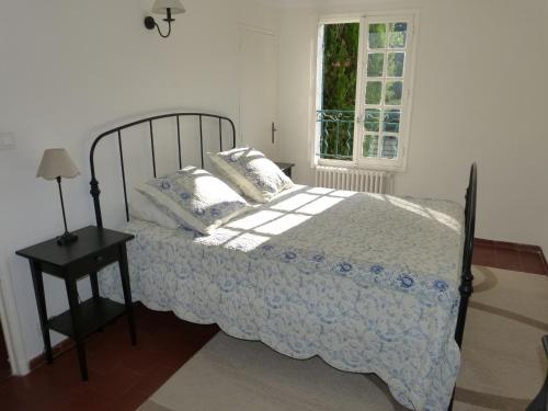 a bedroom with a bed and a table and a window at Bastide de la Madeleine in Aix-en-Provence