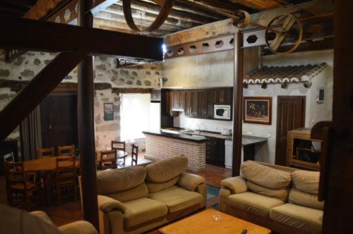 sala de estar con sofás, cocina y mesa en Casa Rural El Molino I, en San Bartolomé de Pinares