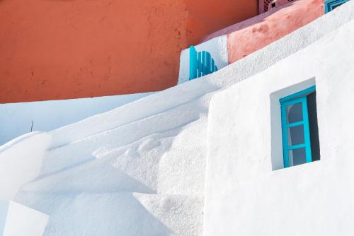 a white building with a blue window on it at Sophia Oia View in Oia