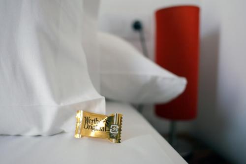 a gold object on a bed with white pillows at Pigal in Tarragona