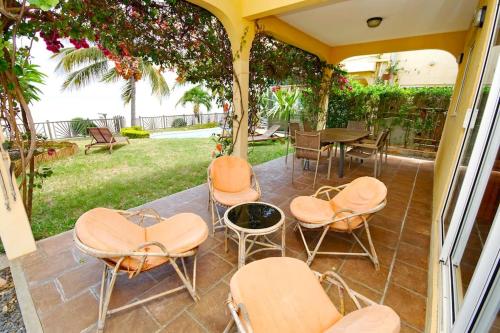 a patio with chairs and a table and a grill at Villa Mauridul in Baie du Tombeau