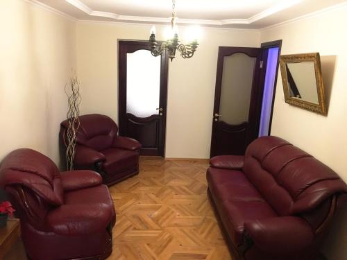 uma sala de estar com duas cadeiras de couro e um sofá em Chekin Imereti em Kutaisi