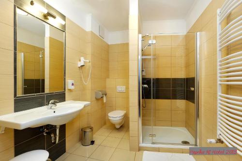 uma casa de banho com um lavatório, um chuveiro e um WC. em Paprika M1 Hotel em Hegyeshalom
