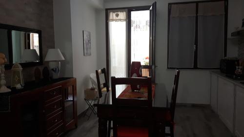 a living room with a table and chairs and a window at Little house in Alghero