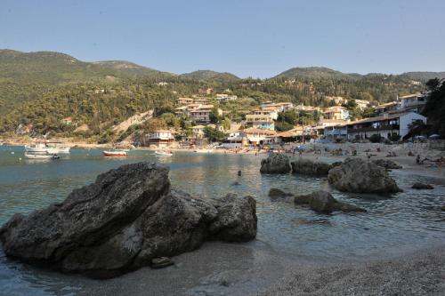 a beach with rocks and people in the water at Hotel Agios Nikitas in Agios Nikitas