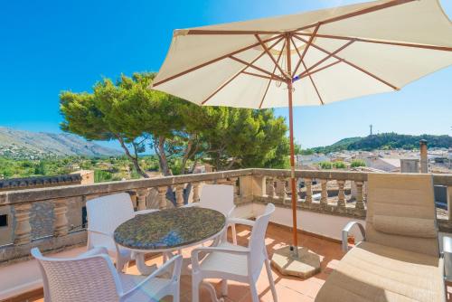 a patio with a table and chairs and an umbrella at Calvari in Pollença