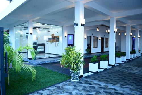 a lobby with potted plants in a building at Liyonaa Beach Hotel in Trincomalee