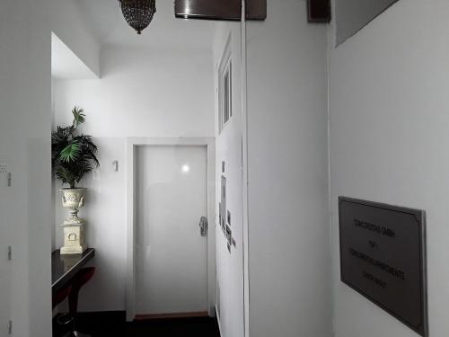 ウィーンにあるConcorditas Apartmentsの白いドアとテレビのある廊下