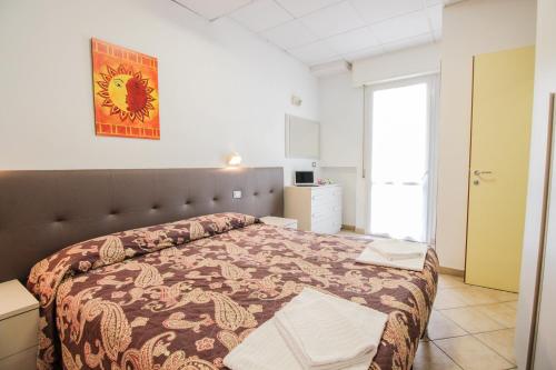 una camera con un letto in una stanza con una finestra di Residence Eurogarden a Rimini