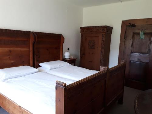 a bedroom with two beds and a cabinet at Castel Pergine in Pergine Valsugana