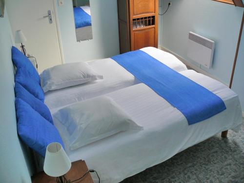 a large bed with blue and white sheets and pillows at Hôtel Le Vivier WISSANT - Centre Village - Côte d'Opale - Baie de Wissant - 2CAPS in Wissant