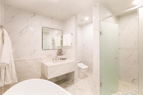 a white bathroom with a sink and a shower at Nampo Hound Hotel Premier in Busan