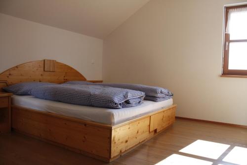 1 dormitorio con 1 cama con marco de madera en Le Maier, en San Vigilio Di Marebbe