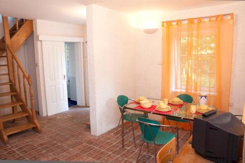 a dining room with a table and green chairs at Raisa Apartments Fünkhgasse in Pressbaum