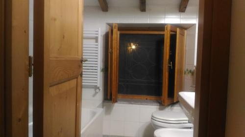 a bathroom with a toilet and a black door at Baduerughe - ValledelLago in Poggio Mirteto