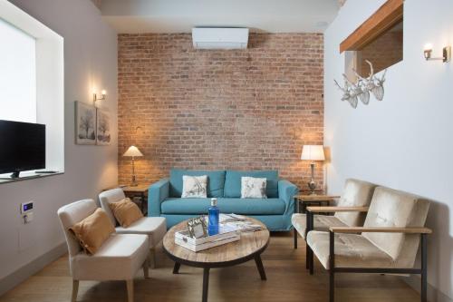 バルセロナにあるBCN ランブラ カタルーニャ アパートメンツのリビングルーム(青いソファ、椅子付)