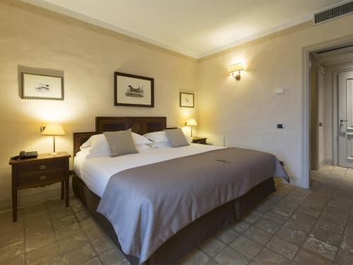 a hotel room with a large bed and two lamps at Relais Sant'Uffizio Wellness & Spa in Cioccaro