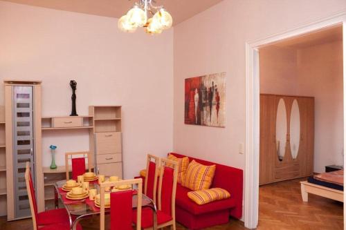 a living room with a table and a red couch at Raisa Apartments Fünkhgasse in Pressbaum