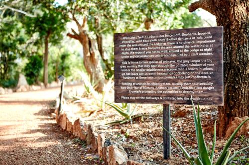 a sign in front of a tree in a park at Wild Coast Tented Lodge - Relais and Chateaux - All Inclusive in Yala
