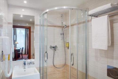 y baño con ducha y lavamanos. en Adria Hotel Prague, en Praga