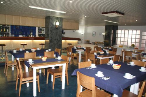a restaurant with blue tables and chairs and a kitchen at Hotel Marqués de Santillana in Torrelavega
