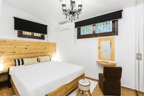 a bedroom with a large white bed and a chair at Evita's Home, a romantic escape, By ThinkVilla in Platanes