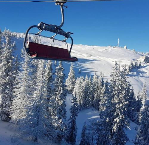 a ski lift in the air with snow covered trees at Apartmani Marija in Jahorina