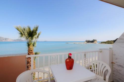 a table and chairs on a balcony with a view of the ocean at Nel Mare Studios in Laganas