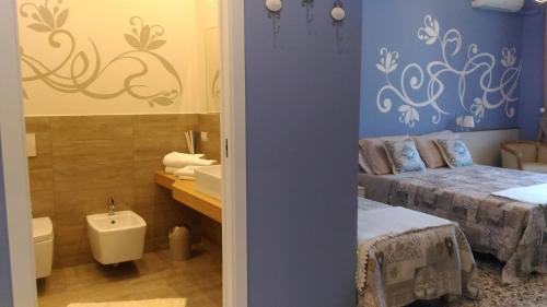 a bathroom with two beds and a sink in a room at B&B Villa Raineri in Giardini Naxos