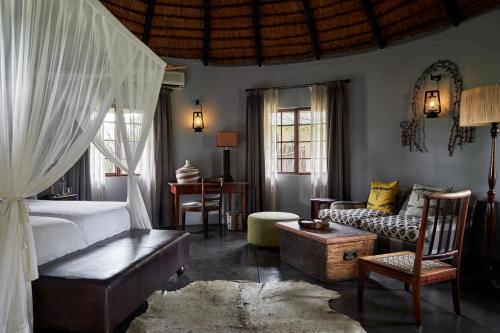 a bedroom with a bed and a living room at Motswari Private Game Reserve by NEWMARK in Timbavati Game Reserve