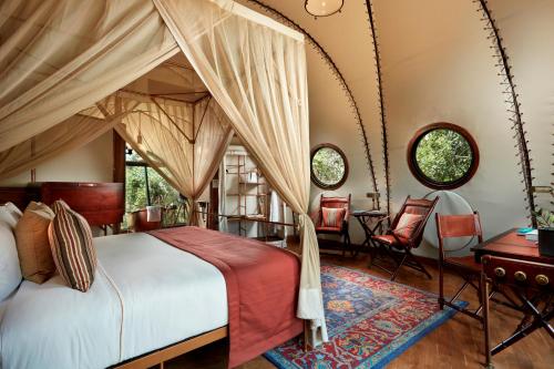 a bedroom with a canopy bed and a table and chairs at Wild Coast Tented Lodge - Relais and Chateaux - All Inclusive in Yala